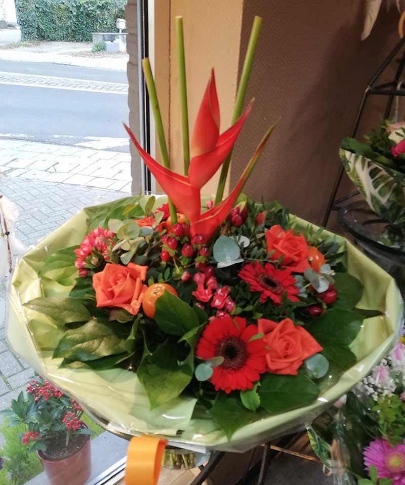 Bouquet exotique en boutique : heliconia, roses orange et gerberas rouges